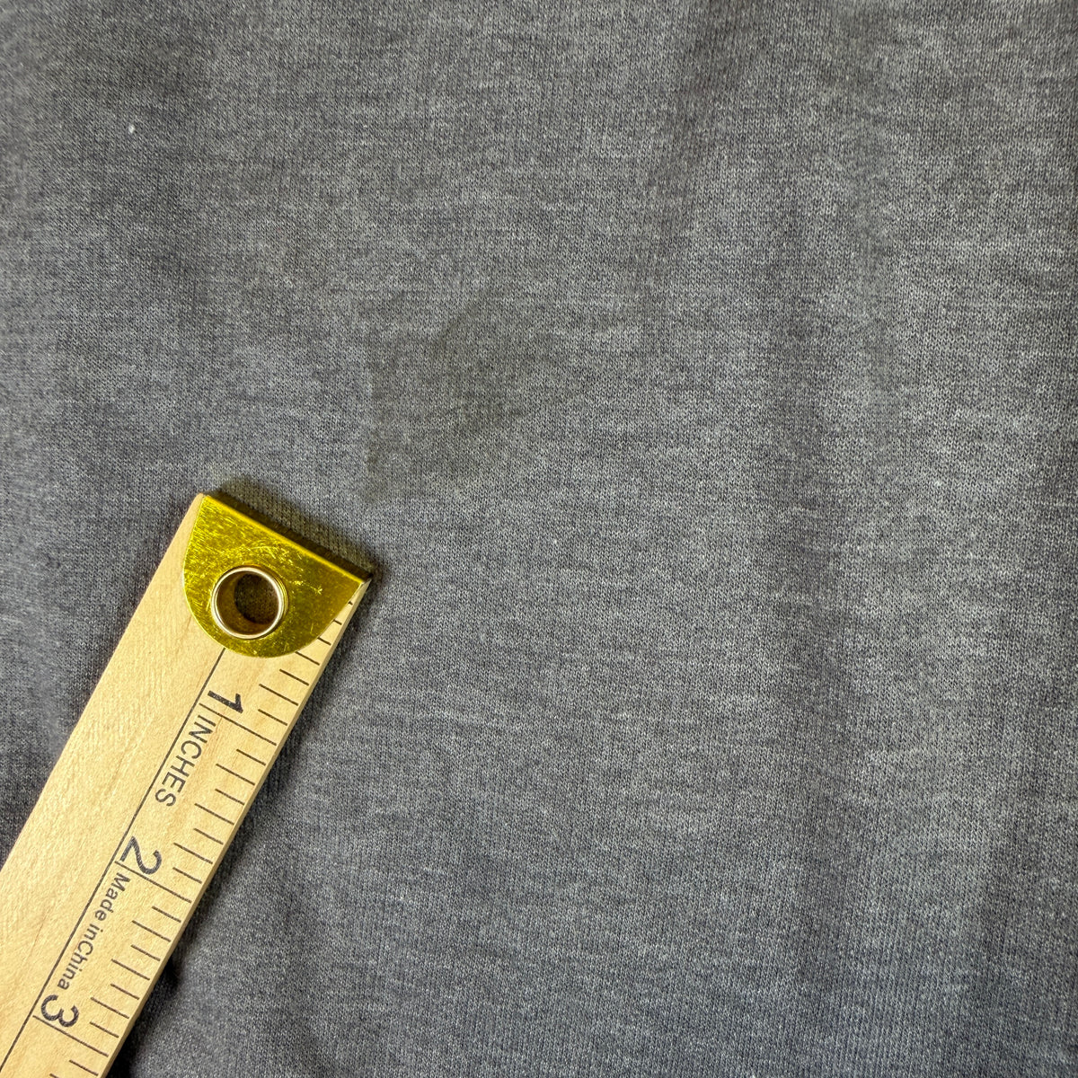 Yardstick across sweatshirt near underarm for sizing reference.