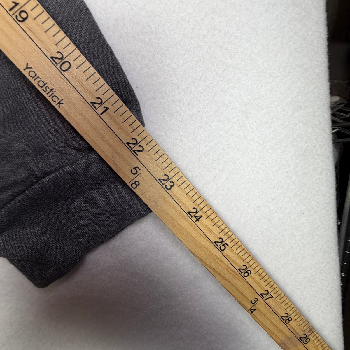 Yardstick beside sweatshirt sleeve and cuff.