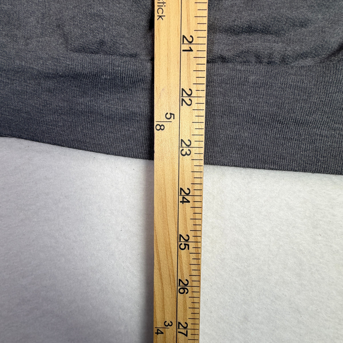 Close-up of faint mark and surface wear on gray sweatshirt fabric.